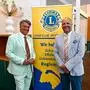 Zwei Männer stehen vor einem Banner des Lions Clubs