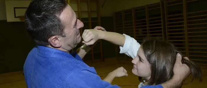 Ein Mann kämpft mit einem Mädchen im Rahmen eines Selbstverteidigungskurses