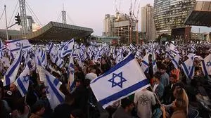 Protesters wave the Israeli flag during a gathering in Tel Aviv on March 27, 2023, amid ongoing demonstrations and calls for a general strike against the hard-right government's controversial push to overhaul the justice system. (Photo by GIL COHEN-MAGEN / AFP)