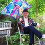 Der Maler Helmut Kand mit Kand-Sakko und Kand-Schirm in seinem wuchernden Garten in Bruck