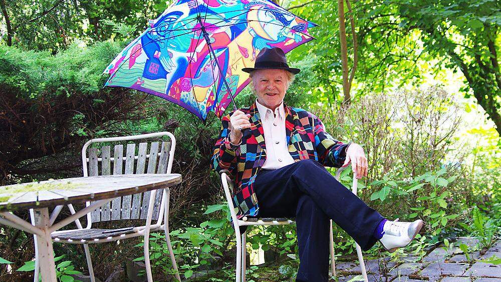 Der Maler Helmut Kand mit Kand-Sakko und Kand-Schirm in seinem wuchernden Garten in Bruck