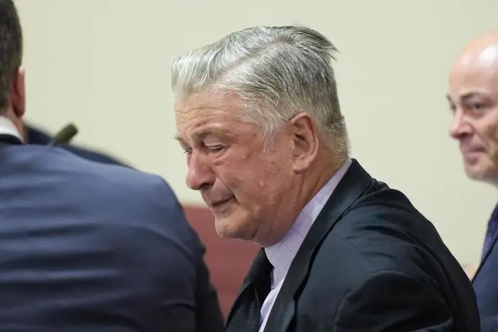 Actor Alec Baldwin, center, reacts as he sits between his attorneys Alex Spiro, left, and Luke Nikas after the judge threw out the involuntary manslaughter case for the 2021 fatal shooting of cinematographer Halyna Hutchins during filming of the Western movie 