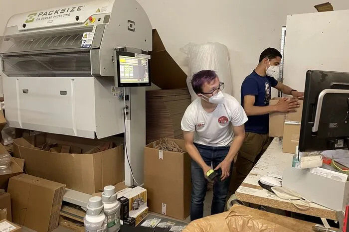 Kevin muss am Computer ebenso arbeiten wie mit den großen Verpackungsmaschinen.
