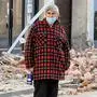 An elderly woman looks on next to rubble and damaged buildings in Petrinja, some 50kms from Zagreb, after the town was hit by an earthquake of the magnitude of 6,4 on December 29, 2020. - The tremor, one of the strongest to rock Croatia in recent years, collapsed rooftops in Petrinja, home to some 20,000 people, and left the streets strewn with bricks and other debris. Rescue workers and the army were deployed to search for trapped residents, as a girl was reported dead. (Photo by DENIS LOVROVIC / AFP)