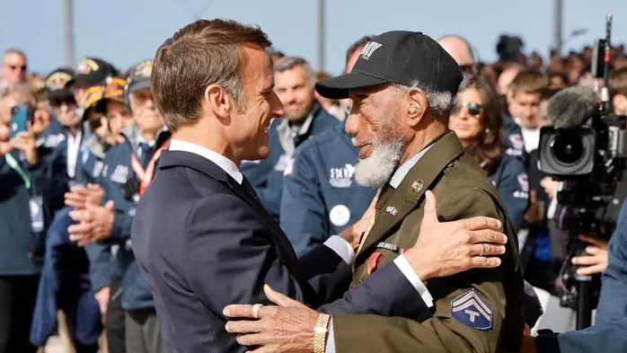 France's President Emmanuel Macron (L) awards US WWII veteran Arlester Brown with the Legion of Honour during the International commemorative ceremony at Omaha Beach marking the 80th anniversary of the World War II "D-Day" Allied landings in Normandy, in Saint-Laurent-sur-Mer, in northwestern France, on June 6, 2024. The D-Day ceremonies on June 6 this year mark the 80th anniversary since the launch of 'Operation Overlord', a vast military operation by Allied forces in Normandy, which turned the tide of World War II, eventually leading to the liberation of occupied France and the end of the war against Nazi Germany. (Photo by Ludovic MARIN / AFP)