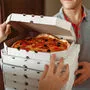 Delivery man shows pizza to customer at the door