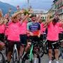 Radfans in rosafarbenen Trikots jubeln. In ihrer Mitte steht Felix Gall