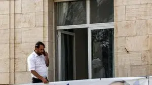 A man speaks on a cell phone from the balcony of a Jerusalem building on October 27, 2022, showing electoral banners for Israel's Likud party depicting its leader former prime minister Benjamin Netanyahu with the Hebrew tagline "only Likud can", ahead of the November general elections. (Photo by RONALDO SCHEMIDT / AFP)
