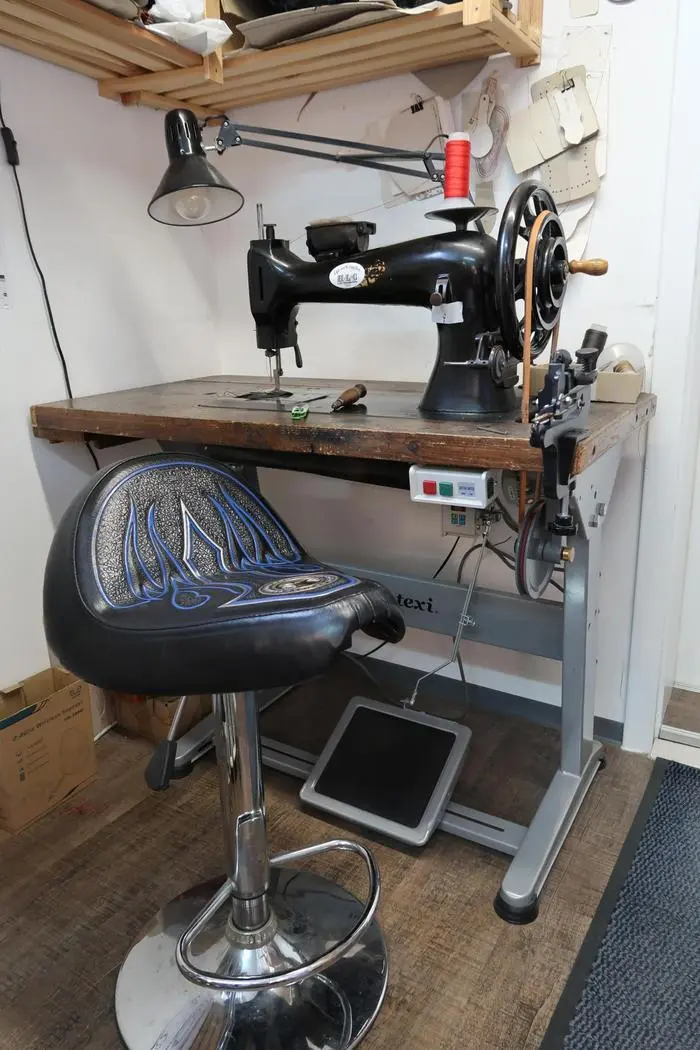 Mit der alten Nähmaschine wird genäht. Den Sessel hat er sich selbst gebaut und gestaltet