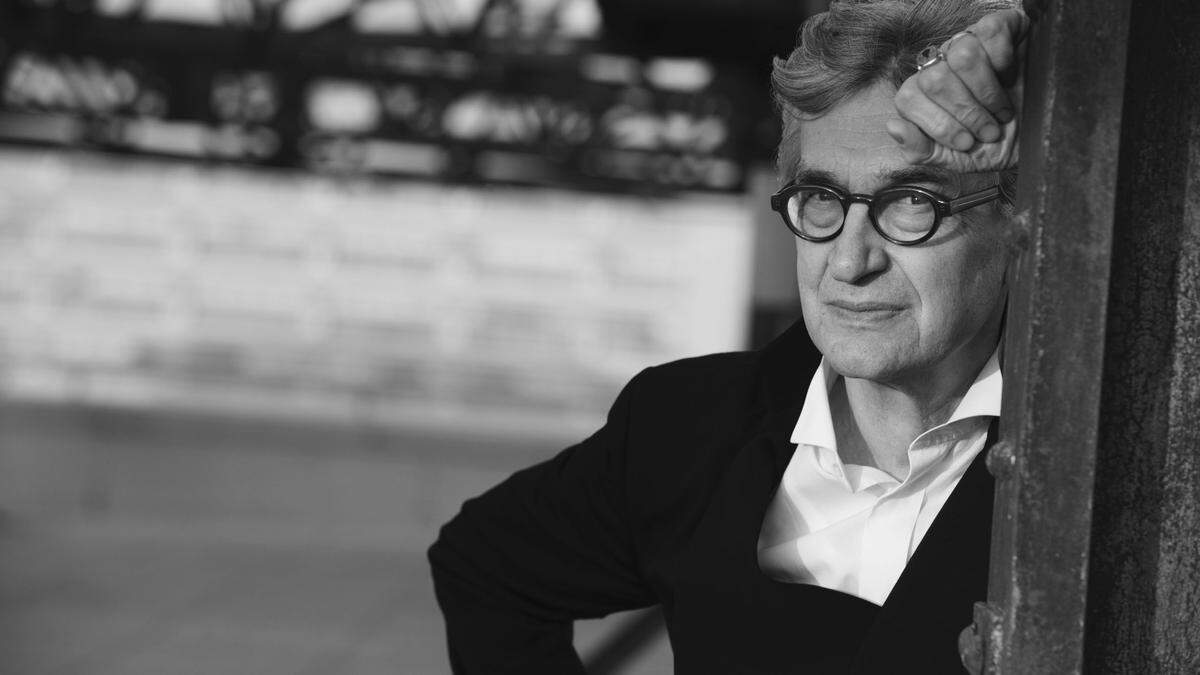 Wim Wenders, fotografiert von Peter Lindenbergh | Wim Wenders lehnt an einem Holzrahmen