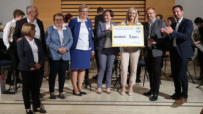 Sabine Kügerl mit dem Scheck für das Ehepaar Reiss