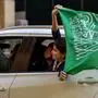 A Saudi football fan waves their country's flag from the window of a car in Riyadh while celebrating after the Qatar 2022 World Cup Group C football match between Argentina and Saudi Arabia on November 22, 2022. (Photo by AFP)