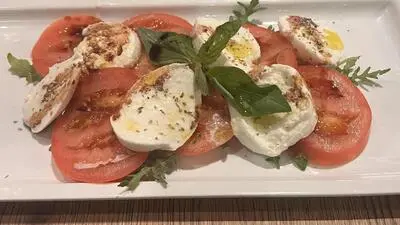 Ein Teller Tomaten, Mozzarella und Basilikum