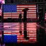 TOPSHOT - People walk past an American Flag display at Time Square on April 11, 2025 in New York City. China said Friday it would raise its tariffs on US goods to 125 percent in a further escalation of a trade war that threatens to bring exports to a halt between the world's two biggest economies. Beijing's retaliation sparked fresh market volatility, with stocks seesawing, gold prices surging and US government bonds under pressure. (Photo by ANGELA WEISS / AFP)