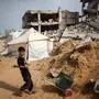 Ein palästinensischer Junge schleppt einen mit Wasser gefüllten Kanister in der Nähe von Gebäuden, die bei israelischen Bombardierungen in Gaza-Stadt zerstört wurden | Ein palästinensischer Junge schleppt einen mit Wasser gefüllten Kanister in der Nähe von Gebäuden, die bei israelischen Bombardierungen in Gaza-Stadt zerstört wurden