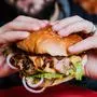 Young man eating a cheeseburger. Restaurant