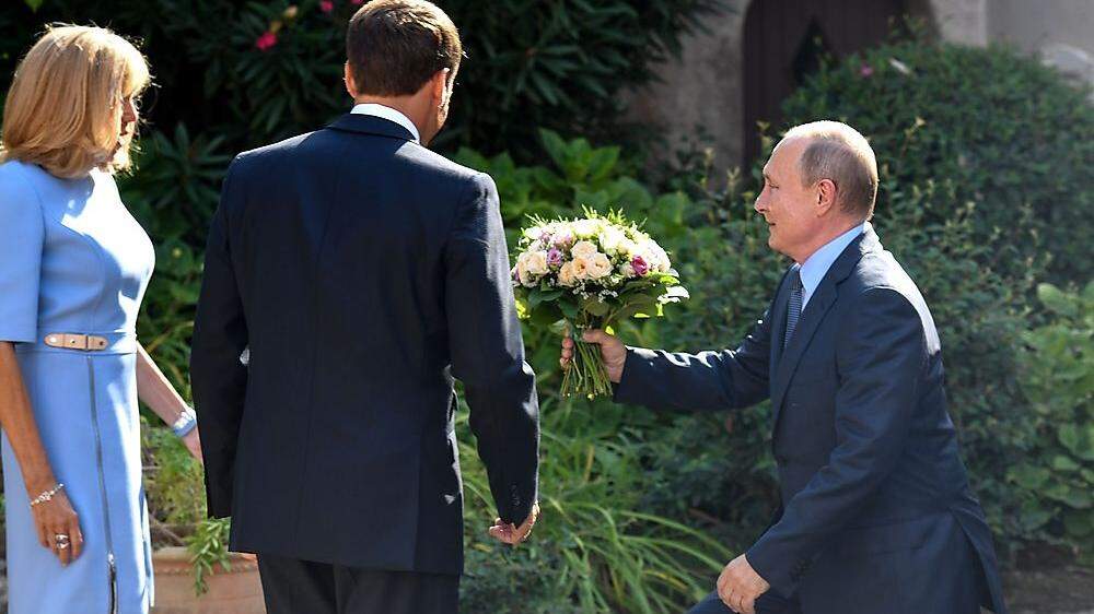 Ganz Gentleman: Putin überreicht Brigitte Macron einen sommerlichen Blumenstrauß beim Arbeitstreffen an der französischen Riviera