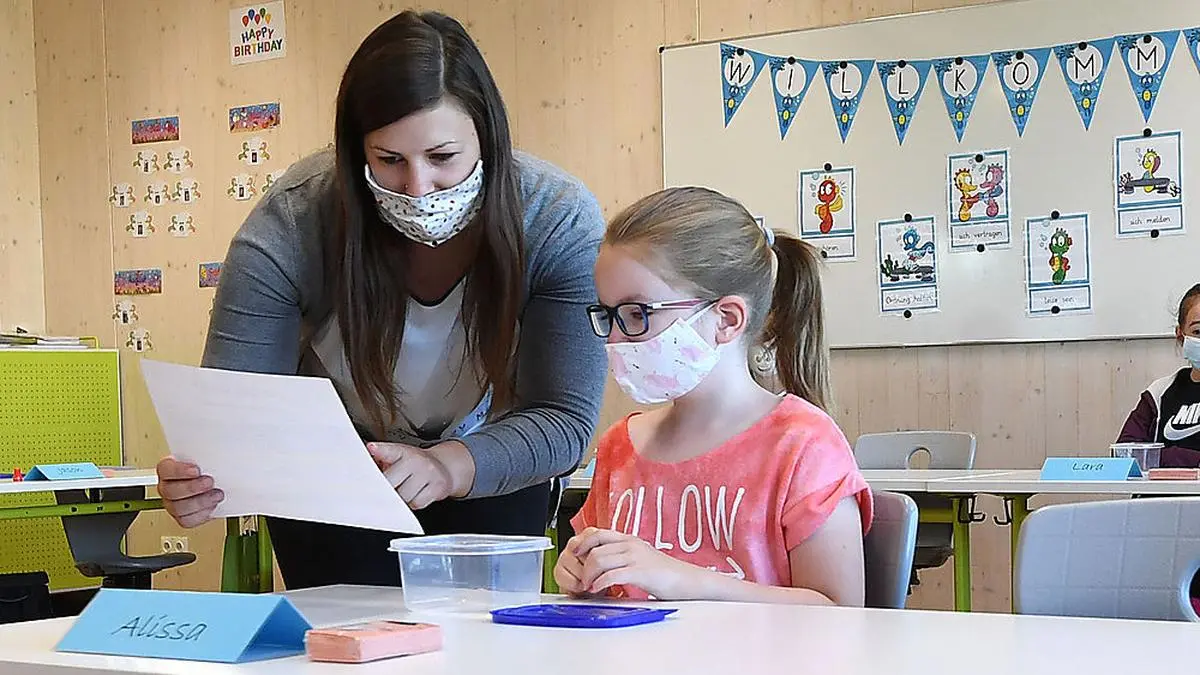 ABD0007_20200518 - BRUNN AM GEBIRGE - ÖSTERREICH: ++ THEMENBILD ++ Illustration zu dem Thema Schulbeginn für Volksschulen, AHS-Unterstufen, Neuen Mittelschulen (NMS) und Sonderschulen nach der Corona-Sperre. Im Bild: Eine Lehrerin unterrichtet eine Schülerin am Montag, 18. Mai 2020, in einer Volksschule in Brunn am Gebirge. - FOTO: APA/HELMUT FOHRINGER