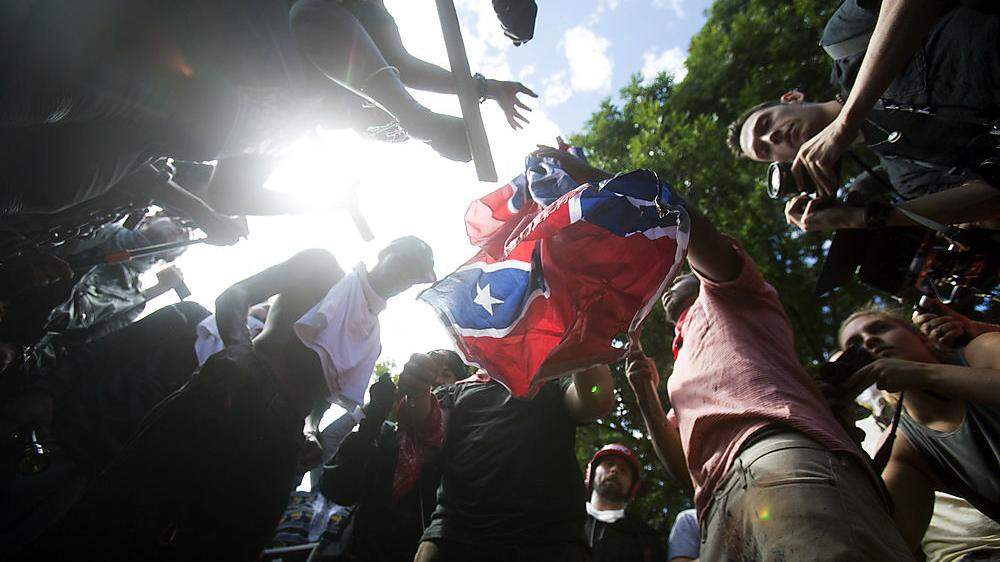 Gegendemonstranten zerreißen eine Konföderierten-Flagge