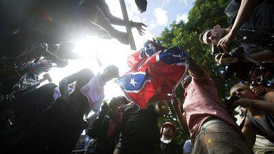 Gegendemonstranten zerreißen eine Konföderierten-Flagge