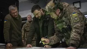 FILE - Ukrainian President Volodymyr Zelenskyy, Commander of Ukraine's Ground Forces Col.-Gen. Oleksandr Syrsky, right, and Roman Mashovets, deputy head of the Presidential Office, look at a map during their visit to the front line city of Kupiansk, Kharkiv region, Ukraine, Thursday, Nov. 30, 2023.  A gloomy mood hangs over Ukraine’s soldiers nearly two years after Russia invaded their country. Ukrainian soldiers remain fiercely determined to win, despite a disappointing counteroffensive this summer and signs of wavering financial support from allies.  (AP Photo/Efrem Lukatsky, File)
