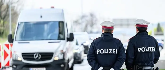 Zwei Polizisten stehen an der burgenländisch-ungarischen Grenze und schauen Richtung eines weißen Lieferwagens | An der burgenländisch-ungarischen Grenze wurden 2022 noch knapp 15.000 Flüchtlinge aufgegriffen – heuer waren es bisher nur mehr 180