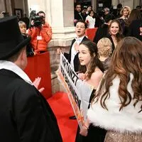 Am roten Teppich vor der Staatsoper enthüllte Klimaaktivistin Lena Schilling mit einem Mitstreiter ein Banner: "Ihr tanzt, wir brennen"