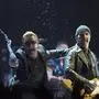 Bono, of the band U2, throws water at the crowd while the Edge watches as they perform in the band's first concert of their new world tour in Vancouver, Thursday, May, 14, 2015. (Jonathan Hayward/The Canadian Press via AP) MANDATORY CREDIT