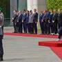 Zum Abschied lässt die Bundeswehr bei einem Großen Zapfenstreich rote Rosen für Angela Merkel regnen