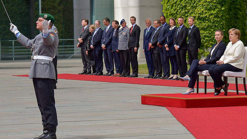 Zum Abschied lässt die Bundeswehr bei einem Großen Zapfenstreich rote Rosen für Angela Merkel regnen