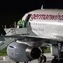 An airport worker closes the door of a Germanwings airplane at the airport in Duesseldorf, western Germany, on December 30, 2019, as the cabin crew at Lufthansa subsidiary Germanwings began a planned three-day strike. - As well as demanding higher wages, especially for entry-level jobs, the German cabin crew union UFO is seeking better benefits and easier routes into long-term contracts. (Photo by Marcel Kusch / dpa / AFP) / Germany OUT
