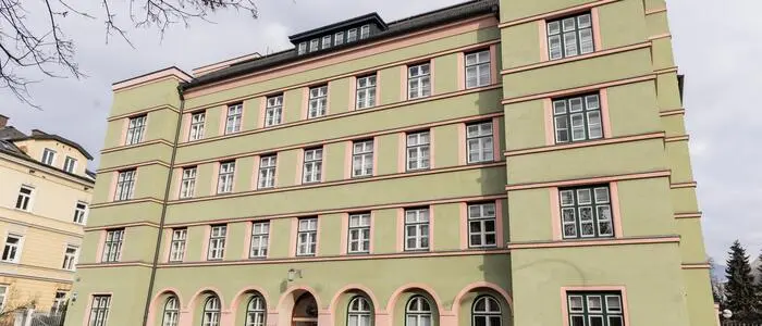 Ein mehrstöckiges Gebäude mit grüner Fassade