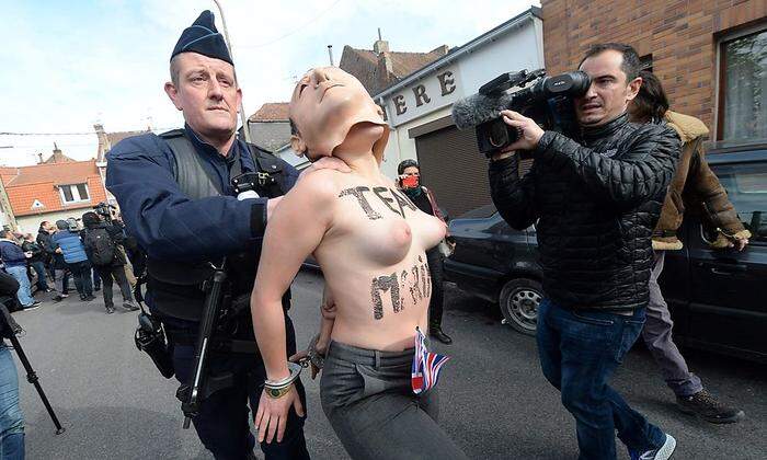 Eine Femen-Aktivistin wird abgeführt 