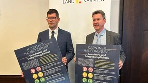 Zwei Männer halten Tafeln in Händen