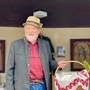 Man sieht einen Mann mit Hut, Korb und grauem Bart