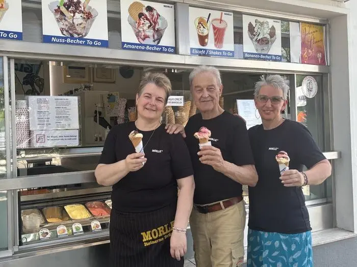 Drei Eisverkäufer vor der Eistheke | Yvonne, Thomas und Michaela Truppe freuen sich über den regen Zulauf bei heißen Temperaturen