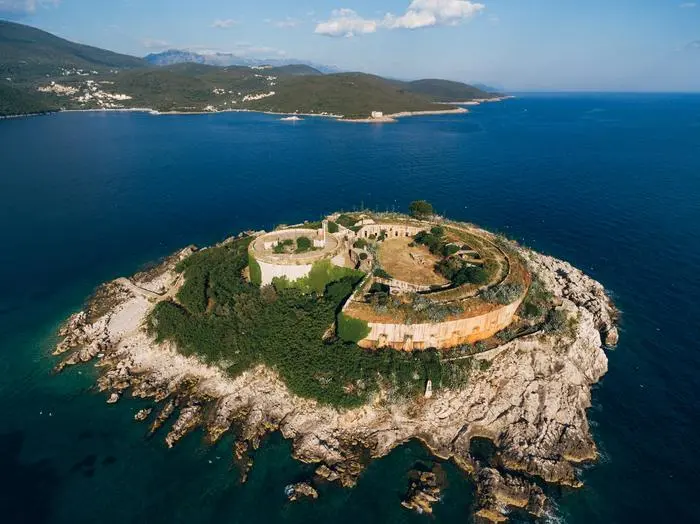 Fortress  on  the  island  of  Mamula  in  the  Kotor  Bay.  Montenegro.  High  quality  photo xkwx architecture,  heritage,  fortress,  island,  mamula,  kotor,  bay,  montenegro,  drone,  nature,  stone,  fort,  wall,  ancient,  water,  fortification,  old,  tower,  landscape,  blue,  sea,  outdoor,  rock,  reef,  ruin,  lastavica,  military,  landmark,  balkans,  building,  shore,  historic,  prison,  beach,  boka,  kotorska,  nobody,  green,  scenic,  seascape,  beautiful,  adriatic,  mediterranean,  coast,  tourism,  travel,  aerial,  view
