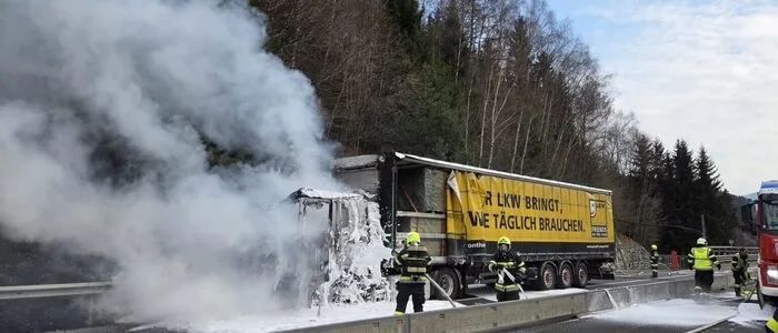 Man sieht Einsatzkräfte, die gerade einen Lkw gelöscht haben