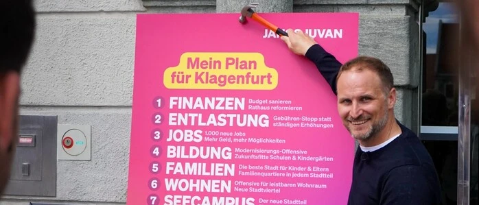 Janos Juvan (Neos) hat er zehn Forderungen aus seinem Plan am Klagenfurter Rathaustor „angenagelt“. 