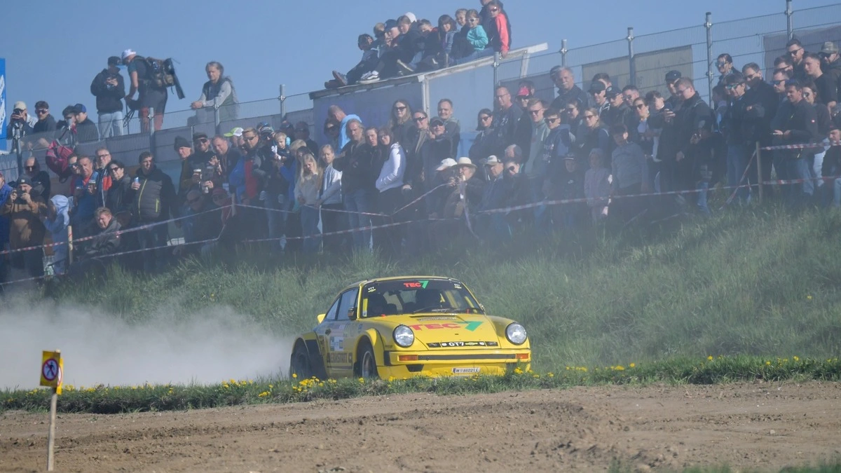 Ein gelbes Auto wirbelt Staub auf, im Hintergrund steht eine Masse an Zuschauern | Neben der Rallye finden auch viele weitere Veranstaltungen im Lavanttal statt