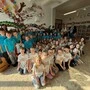 Man sieht 50 Kinder mit ihren Musiklehrern 