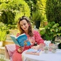 Eine Frau sitzt an einem Tisch und liest ein Buch