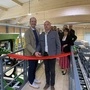 Gero Springer und Anton Cimenti (von links) beim Eröffnen der Sawbox. Sie stehen in der neuen Maschinenhalle und schneiden gerade ein rotes Band durch.