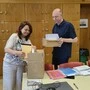 Zwei Personen stapeln Unterlagen in Kartons