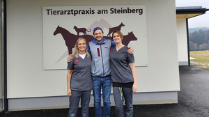 Zwei Frauen stehen links und rechts, in der Mitte ein Mann und lachen vor einer Tierarztpraxis in die Kamera | Rosana Schiaffino de Kunauer, Patrick Volgger und Svenja Stadler (von links)