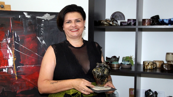 Eine Frau hält ein Kunstwerk auf Ton in der Hand