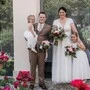 Braut und Bräutigam mit ihren Töchtern lachen in die Kamera