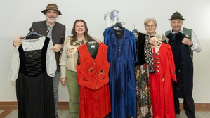 Vier Menschen präsentieren Trachtenkleidung