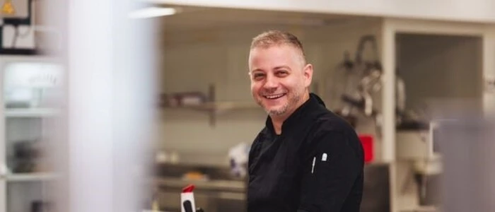 Man sieht einen lächelnden Mann am Herd stehen | Daniel Gadanecz steht, wie jetzt bekannt gegeben wurde, seit 1. Februar an der Spitze des Küchenteams im Falkensteiner Schlosshotel in Velden