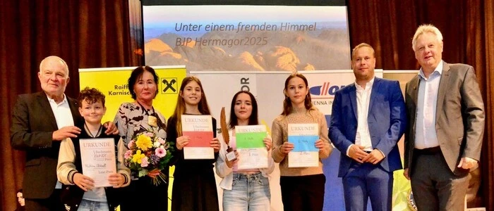 Acht Personen stehen mit Urkunden auf einer Bühne | Stadtrat Karl Tillian, Matthias Strömpfl, Irmgard Janschitz, Anna Wieser, Cansu Gökkaya, Preisübernehmerin Lorena Gailer für Anne Fritz, Kulturreferent Wolfgang Wallner und Bürgermeister Leopold Astner